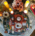 A styled flat-lay of a candles, honey jar, cookie, honey cubes, bookmarks and other bookish items.